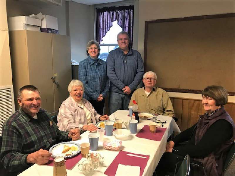 Robert Kirk stands beside Rev. Laurie McNeill and members of his family at a fundraiser to benefit his deli at the First Presbyterian Church of Marlboro on Sunday.